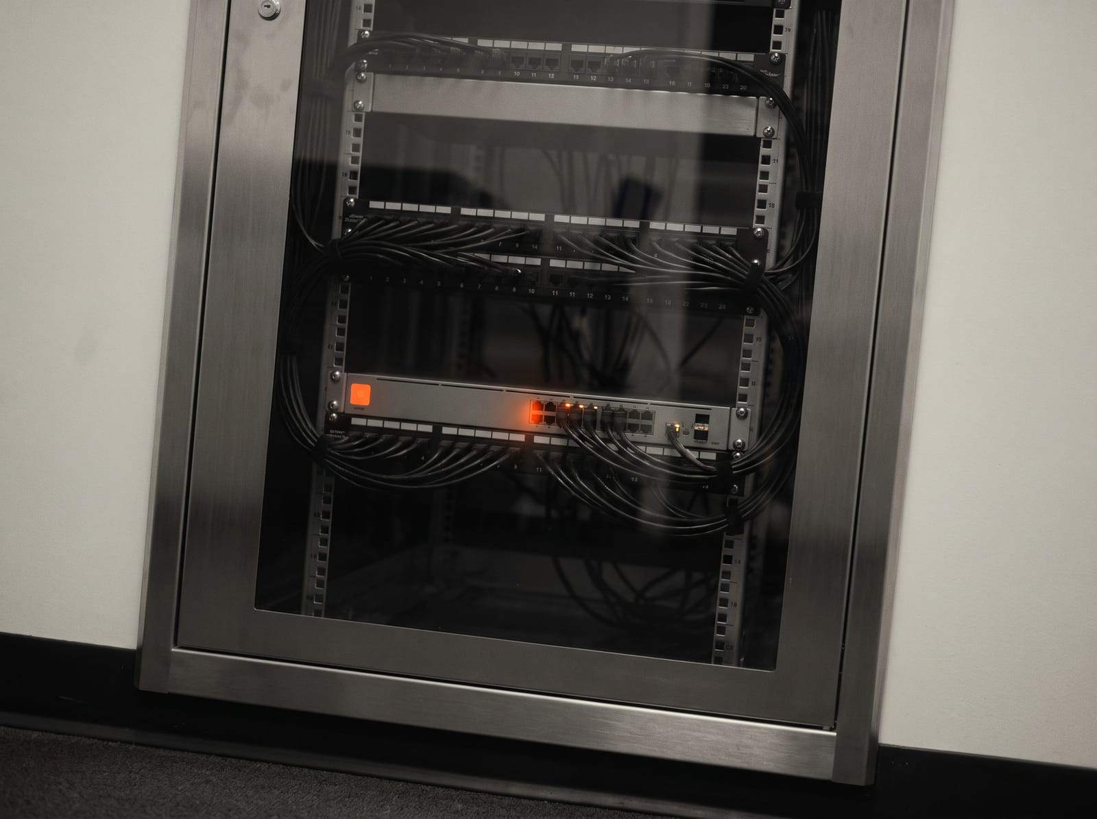 A tidy network cabinet behind smoked glass
